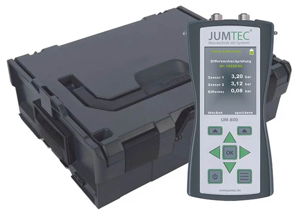 JUMTEC Gerät zur Differenzdruckprüfung mit zwei Sensoren, Display zeigt Druckwerte in bar, daneben ein stabiler Transportkoffer. Marke Syr ist erkennbar.